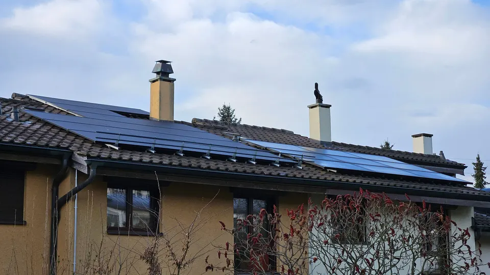 Modules solaires noirs sur le toit en tuiles d’une maison individuelle à Matran