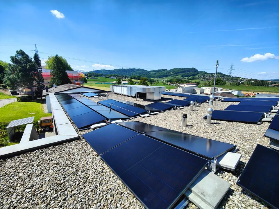 Schwarze Solarmodule auf dem Flachdach eines Einfamilienhauses in Bossonnens (Umgebung: Wiesen)