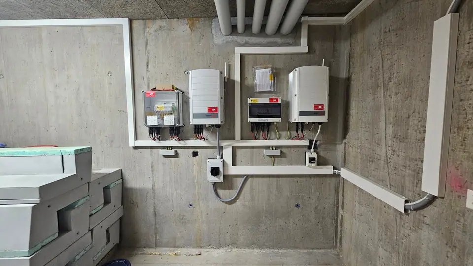 Local technique de l’immeuble à Châtel-St-Denis : deux onduleurs avec coffrets de protection et de distribution au mur