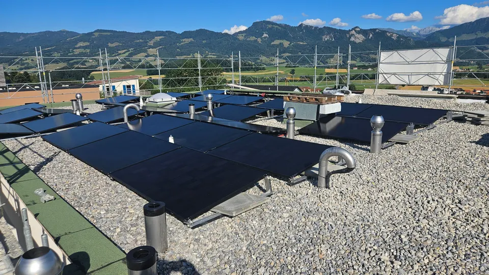 Modules solaires noirs sur le toit plat d’une villa neuve à Marsens (environs : montagnes)