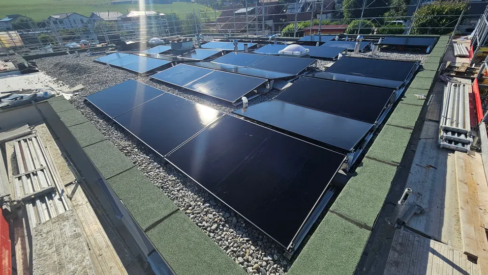 Schwarze Solarmodule auf dem Flachdach eines neuen Einfamilienhauses in Marsens
