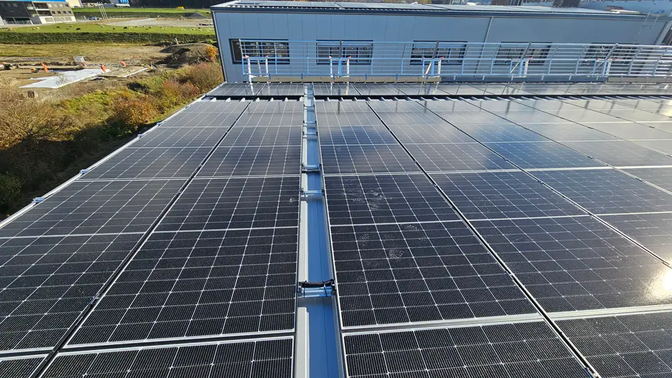 Grand champ de modules solaires sur le toit en tôle de la halle à Rossens