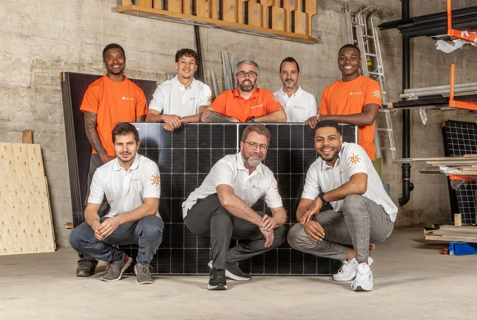 L’équipe de Dimension Solaire devant un module solaire au dépôt de Bulle